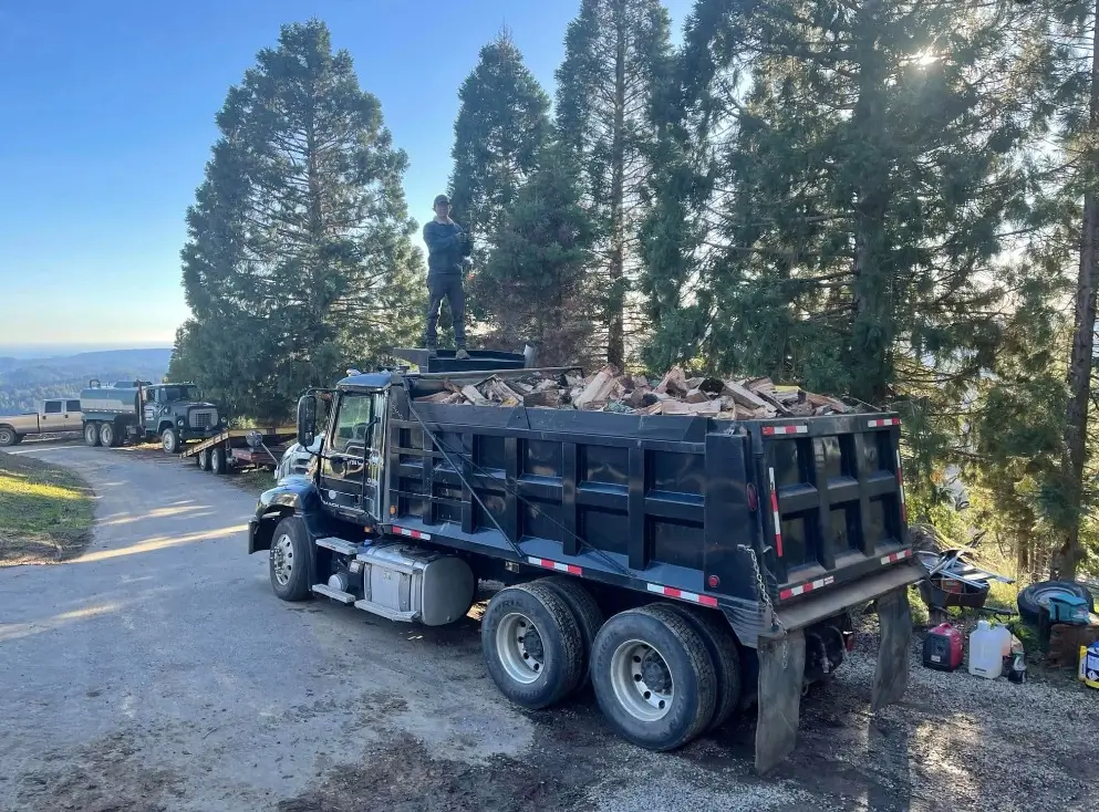 Heavy hauling dump truck fleet and water support vehicle at excavation site in Bay Area CA